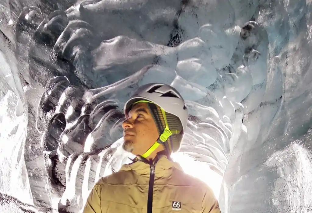 A man is looking at the walls of the Katla Icecave Iceland