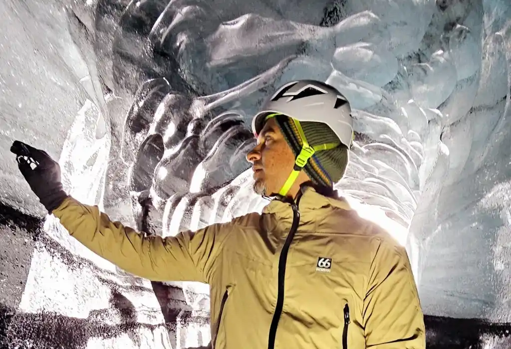 A man touching the walls of Katla Icecave Iceland